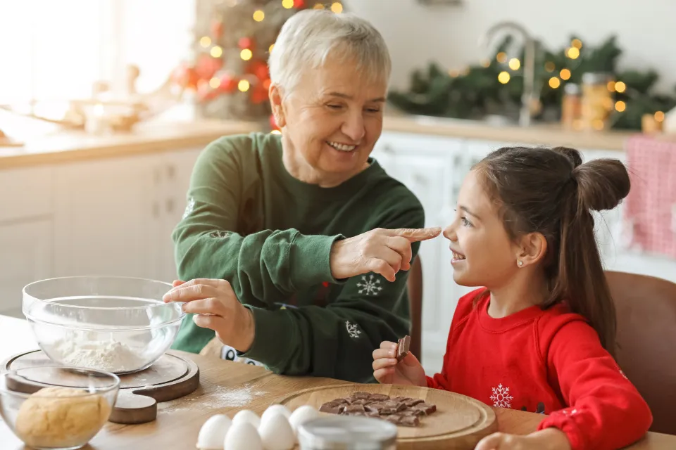 Grandmother and granddaughter laughing together in a kitchen